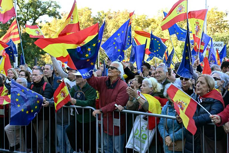 Manifestantes agitam bandeiras da Espanha e da União Europeia em protesto contra um projeto de anistia para pessoas envolvidas na tentativa fracassada de independência da Catalunha em 2017