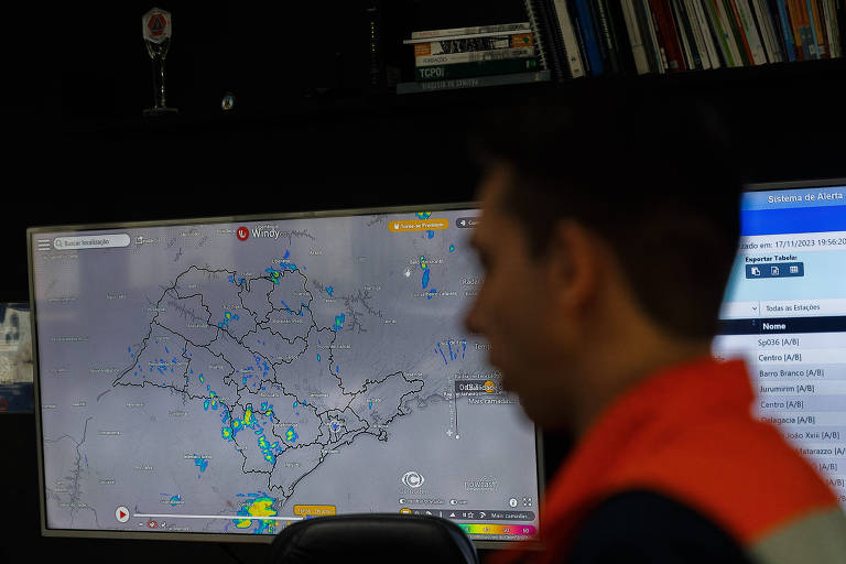 Homem de colete laranja em frente a uma tela com o mapa do estado de São Paulo