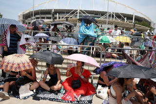 FILE PHOTO: People holding umbrellas wait for the  Taylor Swift concert, in Rio de Janeiro