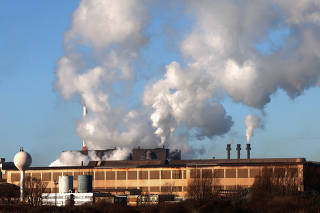 Smoke rises from chimneys at a factory in the port of Dunkirk