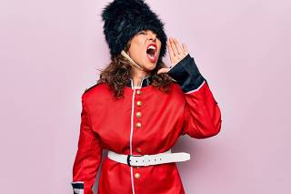 Middle age beautiful wales guard woman wearing traditional uniform over pink background shouting and screaming loud to side with hand on mouth. Communication concept.