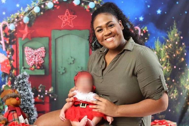 Evelyn Orozimbo posta foto com sua filha, quando era bebê, em seu colo na frente de um cenário alusivo ao Natal