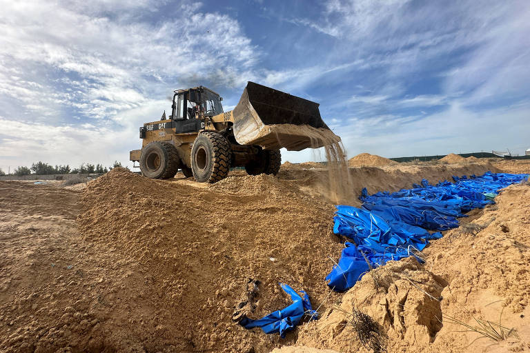 The bodies of Palestinians killed in Israeli strikes and fire are buried in a mass grave, after they were transported from Al Shifa hospital in Gaza City for burial, in Khan Younis in the southern Gaza Strip November 22, 2023. REUTERS/Fadi Shana TPX IMAGES OF THE DAY ORG XMIT: LIVE