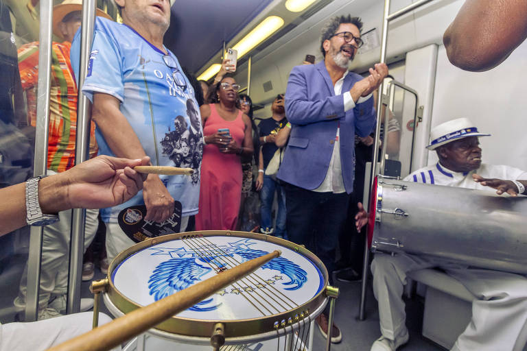 percussionistas de samba em um vagão de trem com seus instrumentos