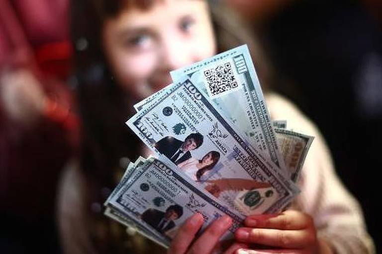 Menina segurando papeis que representam notas de dólar com o rosto de Milei e de sua vice-presidente

