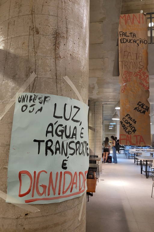 Alunos do campus de Diadema (SP) da Unifesp espalham cartazes durante a paralisação pedindo dignidade para continuarem estudando; o local apresenta muitos problemas na estrutura e na alimentação
