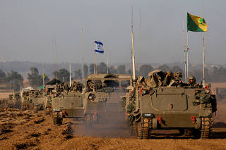 A convoy of Israeli military tanks and Armoured Personnel Carriers (APC) drives by Israel's border after leaving Gaza during the temporary truce between Palestinian Islamist group Hamas and Israel, in Israel
