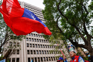 A supporter of the main opposition party Kuomintang (KMT) waves a Taiwanese flag outside of the Central Election Commission, in Taipei