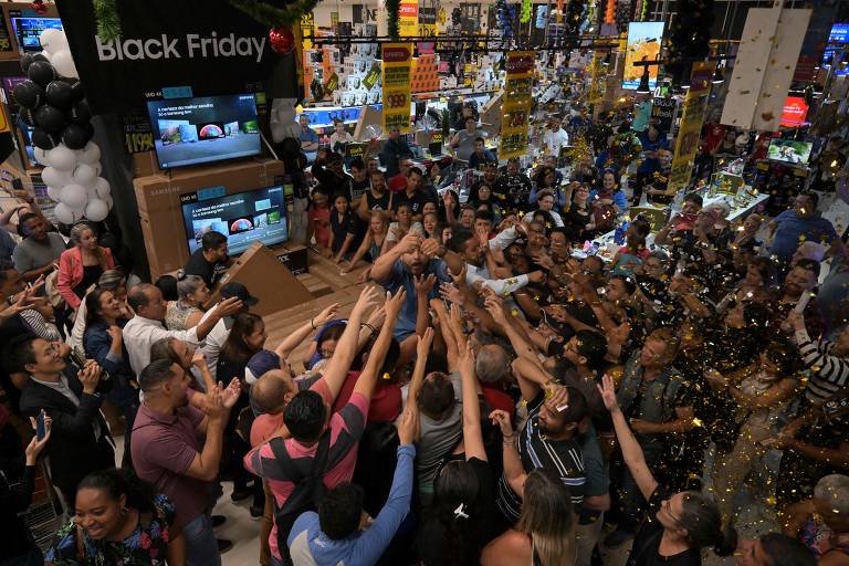 Clientes cercam vendedor em promoção de TVs em loja de São Paulo na Black Friday