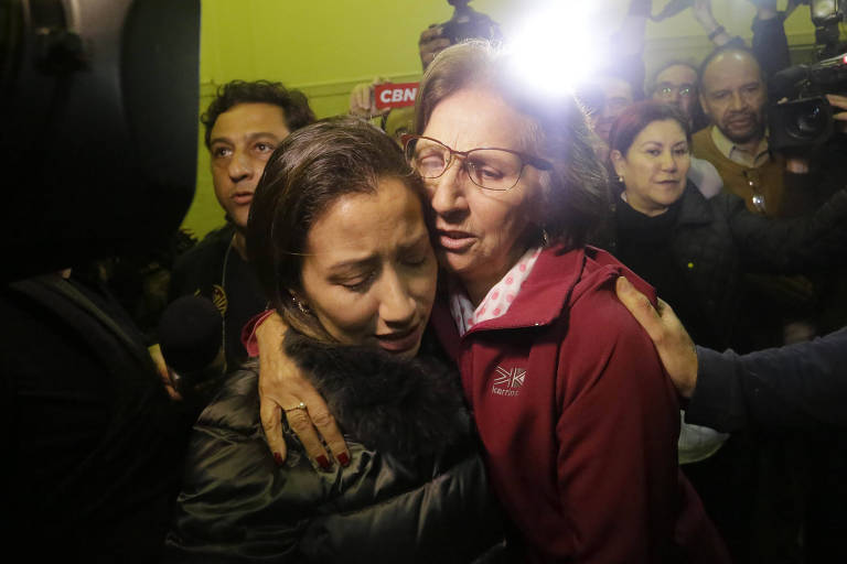 Fabiana Flosi abraça a mãe Aparecida Schunk, sogra de Bernie Ecclestone, ao chegar no Departamento de Homicídios e de Proteção à Pessoa no centro de São Paulo 