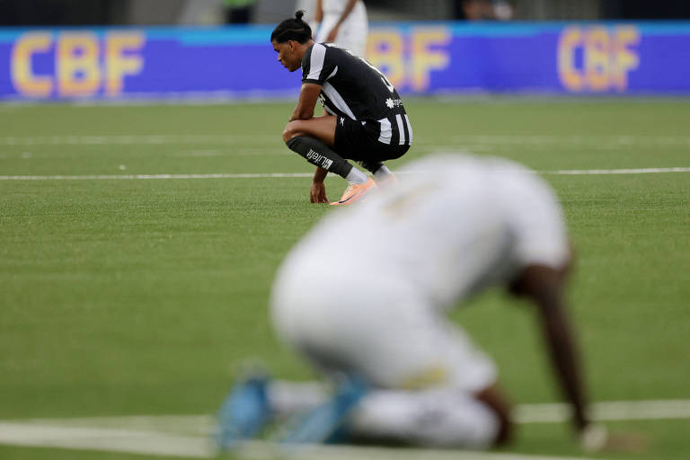 O volante do Botafogo Danilo ajoelha-se no gramado após partida contra o Santos, no Rio de Janeiro 