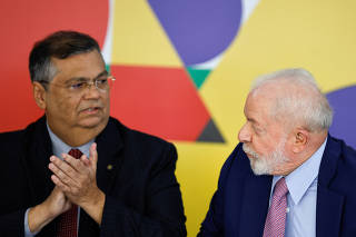 Brazil's president Luiz Inacio Lula da Silva and Brazil's Minister of Justice Flavio Dino look at each other during a press conference in Brasilia