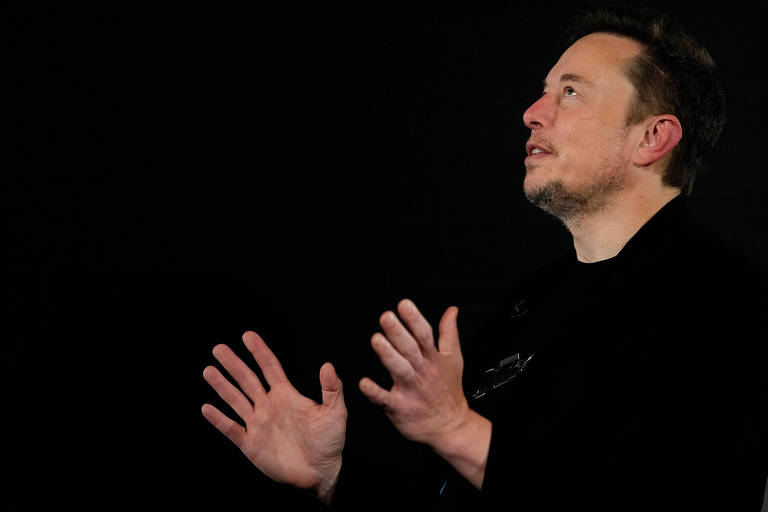 Elon Musk gesticula e abre as duas mãos durante encontro com premiê do Reino Unido, Rishi Sunak