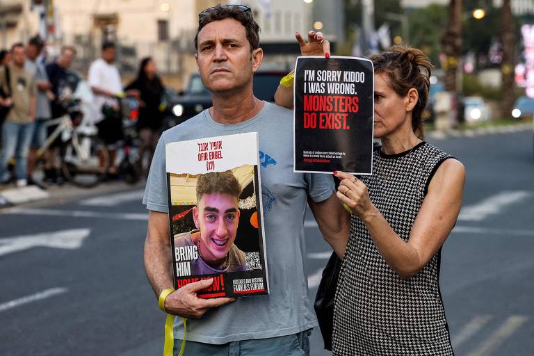 Pessoas seguram cartaz com foto de Ofir Engel, 17, adolescente sequestrado pelo Hamas, durante protesto em Tel Aviv
