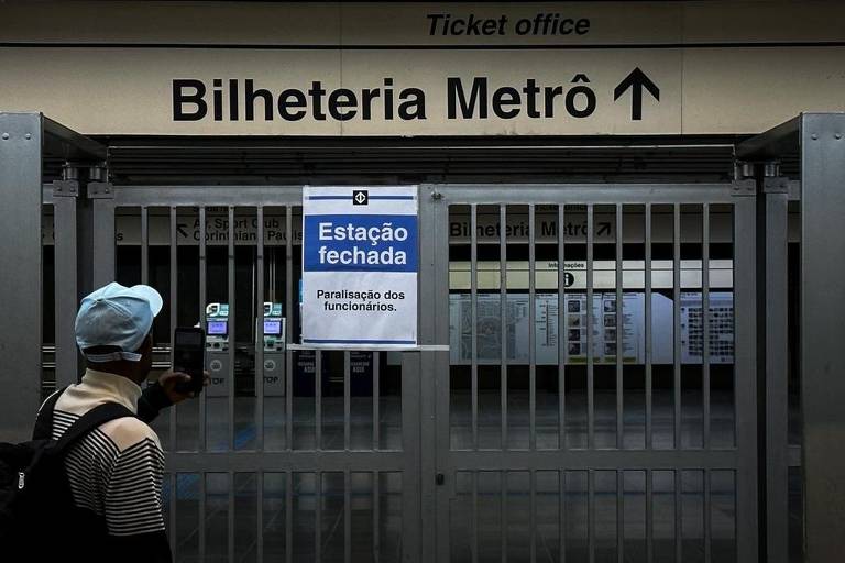 Homem olha para placa que avisa sobre estação fechada no Metrô