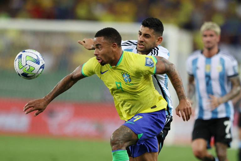 Vestindo camisa amarela, Gabriel Jesus toma a frente de Romero em Brasil versus Argentina, no Maracanã, pelas Eliminatórias da Copa do Mundo de 2026