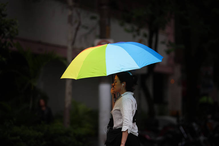 Mulher se protege da chuva com um guarda-chuva