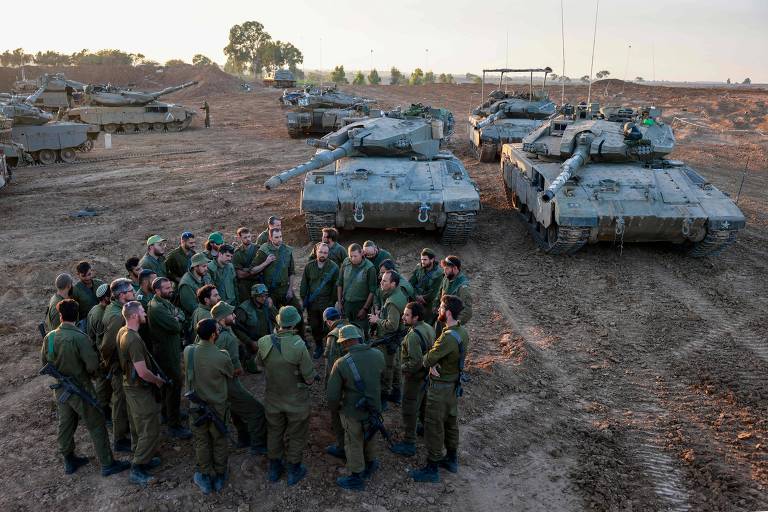 Soldados israelenses reunidos junto a seus tanques durante a trégua com o Hamas, ao sul da Faixa de Gaza