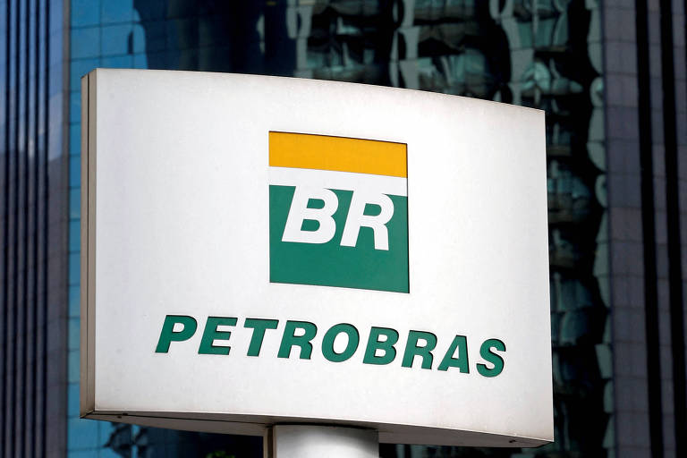 Logo da Petrobras em placa, na frente de um prédio espelhado
