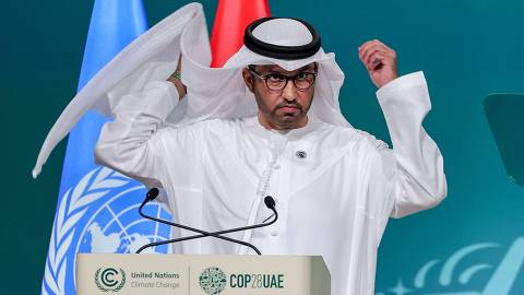 COP28 president Sultan Ahmed Al Jaber adjusts his ghutra, a traditional headdress,  as he speaks during the opening ceremony of the COP28 United Nations climate summit in Dubai on November 30, 2023. The UN climate conference opened in Dubai on November 30 with nations under pressure to increase the urgency of action on global warming and wean off fossil fuels, amid intense scrutiny of oil-rich hosts UAE. (Photo by Giuseppe CACACE / AFP)