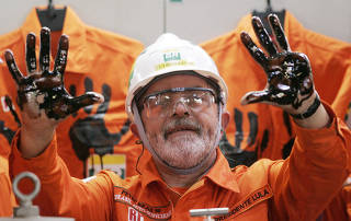 FILE PHOTO: Brazilian President Lula holds up hands covered with oil during ceremony at Petrobras 50 at Campos Basin