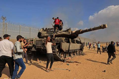 -- AFP PICTURES OF THE YEAR 2023 --

Palestinians take control of an Israeli Merkava battle tank after crossing the border fence with Israel from Khan Yunis in the southern Gaza Strip on October 7, 2023.. One month after Israel was wracked by Hamas attacks, life has been upended for both the Palestinians and Israel after it launched a war of reprisal in the Gaza Strip. The October 7 attacks by Hamas militants who stormed across from Gaza and struck kibbutzim and southern Israeli areas killed 1,400 people, mostly civilians, and deeply scarred the nation. The health ministry in Hamas-run Gaza says nearly 9,500 have been killed, two-thirds of them women and children, and mostly civilians. (Photo by SAID KHATIB / AFP) / AFP PICTURES OF THE YEAR 2023