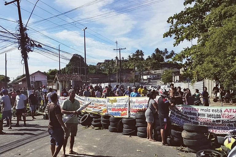 Moradores carregam faixas e empilham pneus