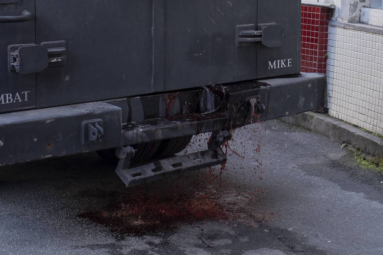 Detalhe da traseira de um caveirão da Polícia Militar do Rio com sangue escorrendo por debaixo das portas 