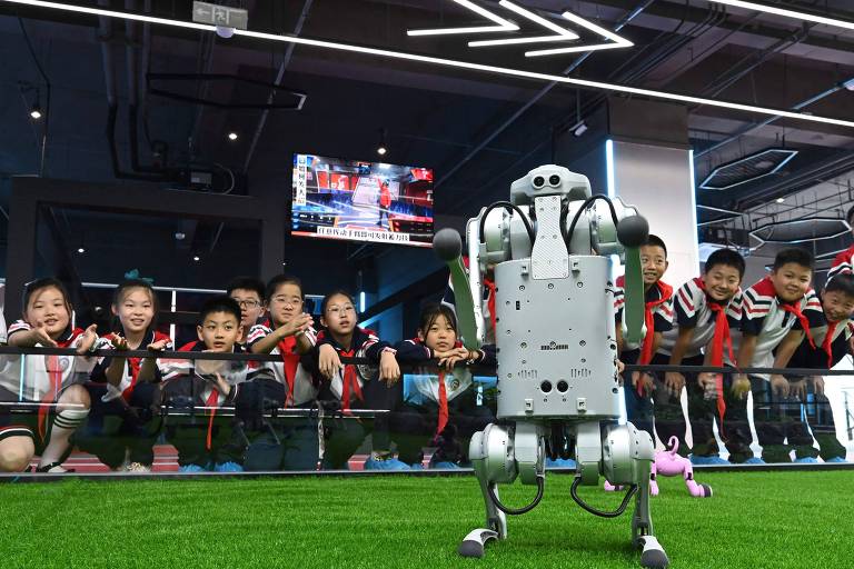 Alunos do ensino básico observam robô que usa inteligência artificial em escola na China