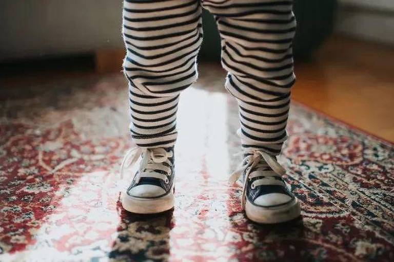 Pernas de um bebê de pé