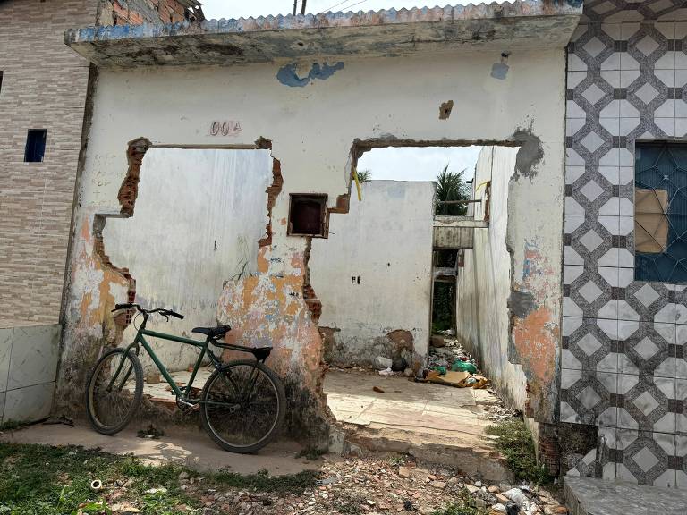 bicicleta em parede com rachaduras e com buraco de dois portões removidos