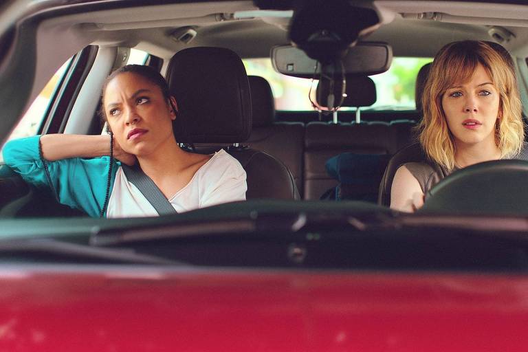 As atrizes Emma Araujo e Bia Arantes, dentro de um carro, com expressões sérias