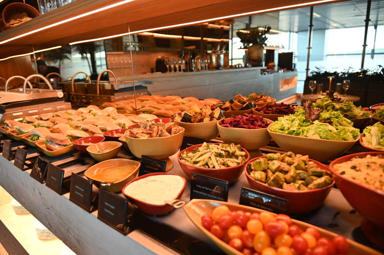 Além de snacks e salgados， buffet das salas VIP também oferece comida fresca e saudável， como saladas， frutas e vegetais; na foto， buffet da Mastercard The Club， no aeroporto de Guarulhos