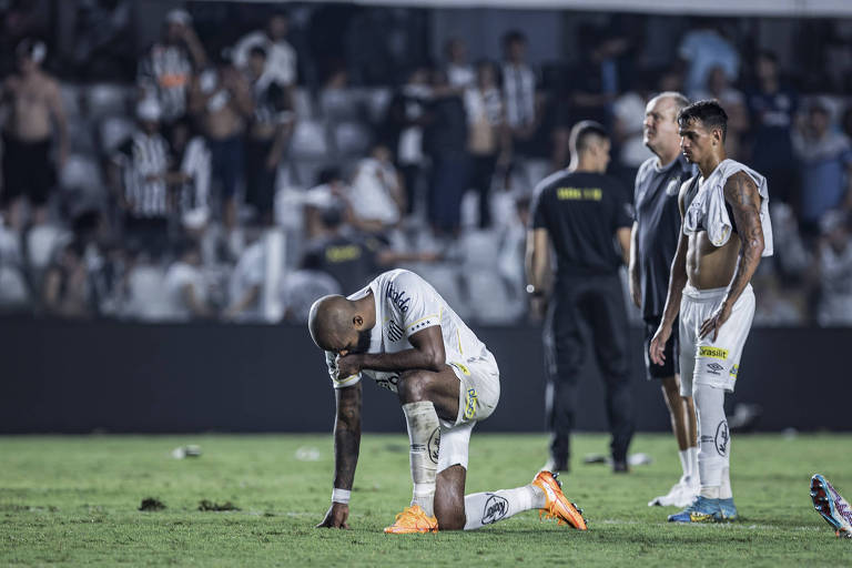 O zagueiro Messias lamenta, ajoelhado, o rebaixamento do Santos no Campeonato Brasileiro da Série A