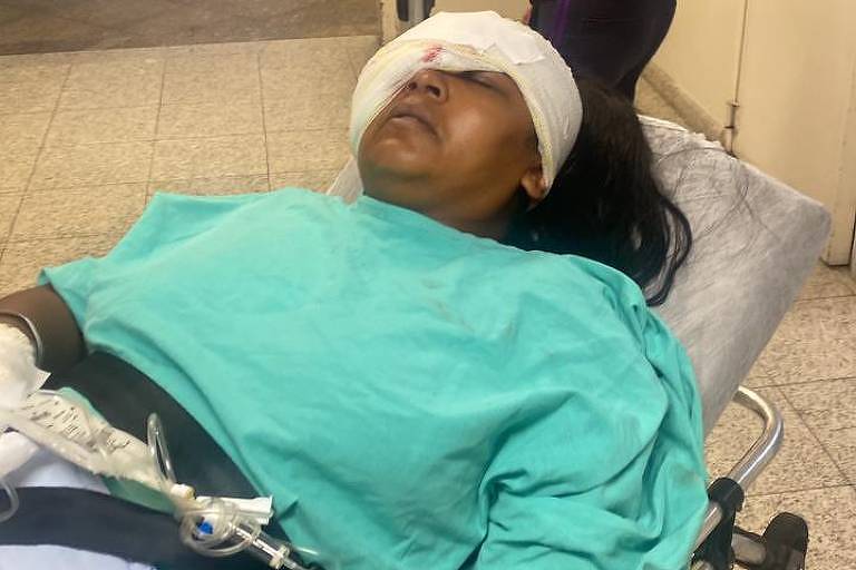 Daiane Cristina Santos deitada em uma maca em hospital na  zona leste de SP
