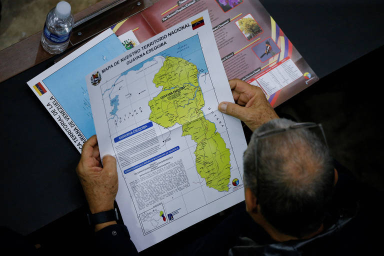 Membro da Assembleia Nacional da Venezuela segura mapa da região disputada de Essequibo em Caracas