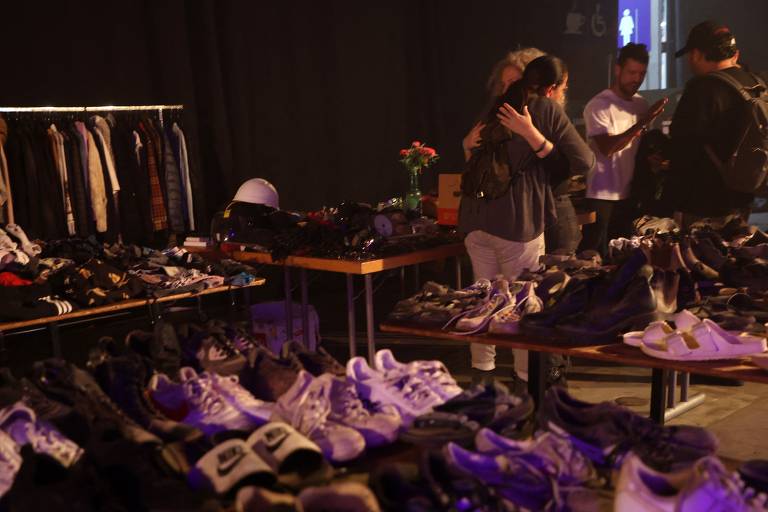 Sapatos e roupas que frequentadores de rave no deserto de Negev deixaram para trás durante invasão do Hamas são exibidos na mostra '06:29', em Tel Aviv