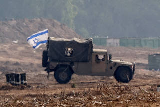 Israeli military vehicles operate at the border with Gaza as seen from southern Israel
