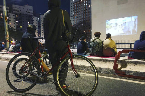 Pedestres e ciclistas assistem a projeção do Cine Minhocão, no elevado Presidente João Goulart, o Minhocão