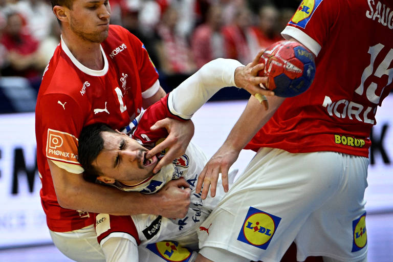O croata Martinovic é agarrado pelo dinamarquês Landin em partida do Mundial de handebol na Suécia