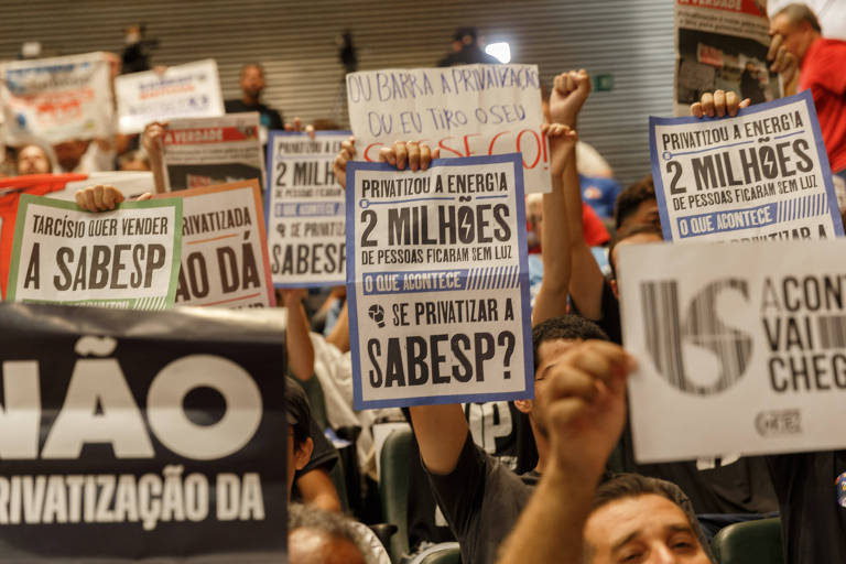 Pessoas segurando cartazes com dizeres contrários à privatização da Sabesp