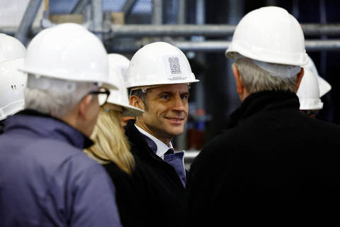 French President Emmanuel Macron, wearing a working helmet, talks with officials as he visits the nave of the Notre-Dame de Paris Cathedral, which was ravaged by a fire in 2019 that sent its spire crumbling down, as restoration works continue a year before its reopening to the public, in Paris, France, December 8, 2023. REUTERS/Sarah Meyssonnier/Pool ORG XMIT: PAR12