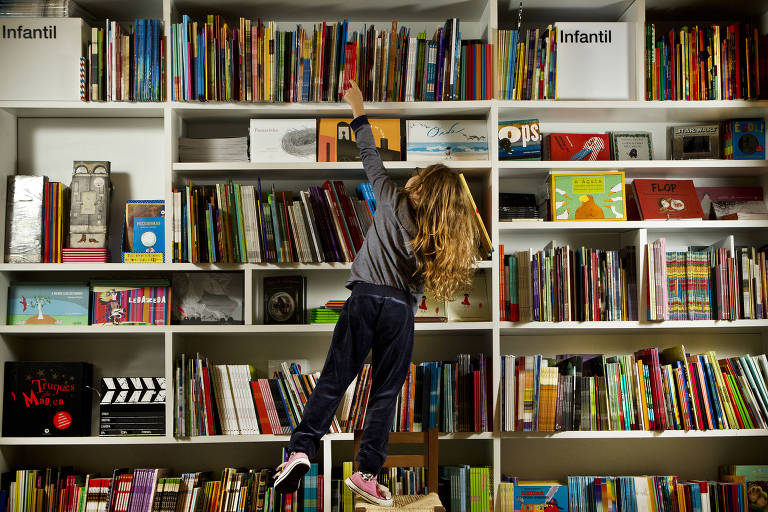 Criança escolhe livros em estante da Livraria da Vila do Shopping Higienópolis, em São Paulo