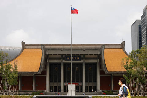 FILE PHOTO: People walk near a fluttering Taiwanese flag outside the Sun Yat-Sen Memorial Hall in Taipei, Taiwan November 16, 2023. REUTERS/Carlos Garcia Rawlins/File Photo ORG XMIT: FW1