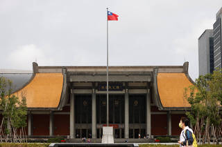 FILE PHOTO: People walk near a fluttering Taiwanese flag outside the Sun Yat-Sen Memorial Hall in Taipei