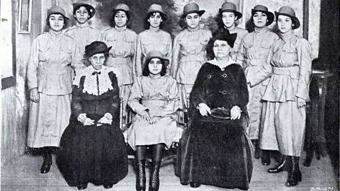 Izabel Dillon (esq.) e Leolinda Daltro (dir.), secretária e presidente do Partido Republicano Feminino, são fotografadas junto às alunas da Escola Orsina da Fonseca / 