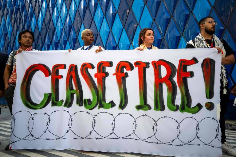 Quatro pessoas seguram cartaz que diz 'cessar fogo' em inglês