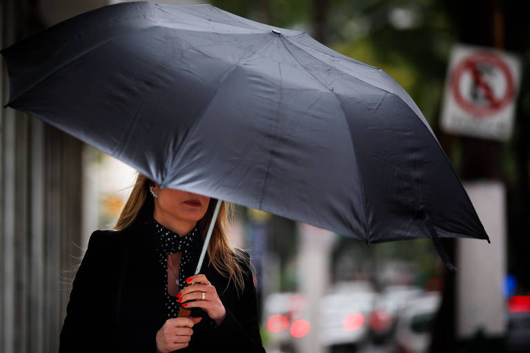 Mulher se protege com um guarda-chuva