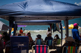 Gazebos de camping são usados por turistas na praia Martim de Sá