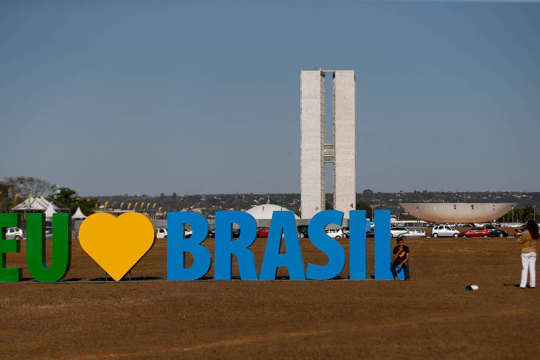 Esplanada dos ministérios ao fundo com placa que forma Eu amo Brasil.